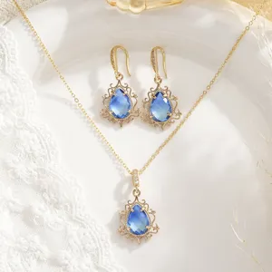 Vista detallada del conjunto de joyas doradas con cristales azules en forma de gota
