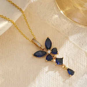 Gros plan d'un collier élégant avec fleur à quatre pétales, saphirs bleus et chaîne dorée