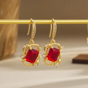 Detailed macro view of vintage Chinese style earrings with red crystal pendants.