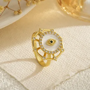 Primer plano de un anillo giratorio de ojo de mal en cobre chapado en oro con circonitas