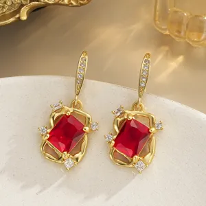 Detailed view of vintage copper earrings with large red crystals in a gold-tone frame.