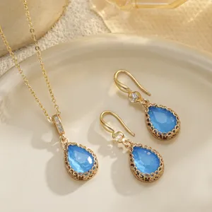 Detailed close-up of bridal jewelry set with blue teardrop stones and gold finish
