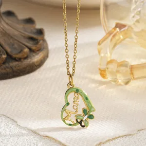 Detailed macro view of a gold-plated heart pendant with green enamel and Mama lettering