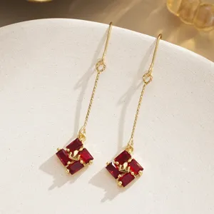 Detailed macro shot of vintage-style long red zircon dangle earrings with elegant gold hooks