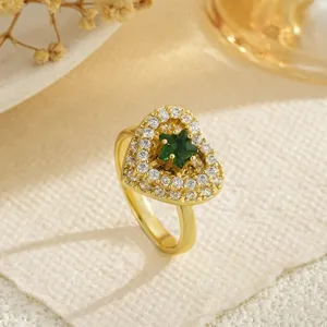 Close-up of a rotating heart-shaped ring with a green star gemstone centerpiece.