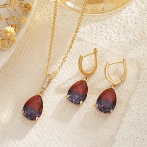 Detail view of gold-plated necklace and earring set with gradient teardrop gemstones
