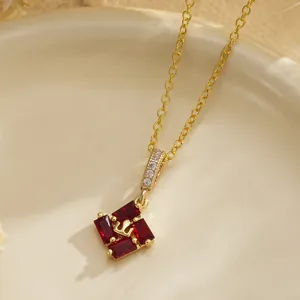 Close-up of vintage palace style necklace with emerald-cut red zircons and gold chain