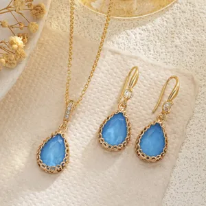 Elegant teardrop blue stone necklace and earring jewelry set with intricate gold hollow design