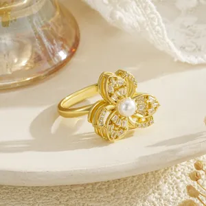 Exquisite gold spinning flower ring with center pearl and sparkling cubic zirconia detail