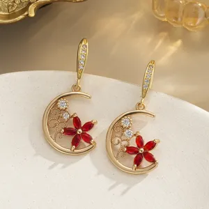 Detail showing vintage copper earrings with red crystal petals and elegant moon pendant