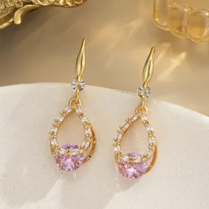 Detailed close-up of elegant gold-plated hollow water drop earrings with pink zircon gems