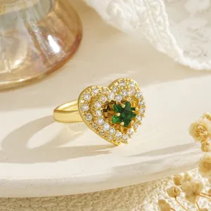 Detailed view of a golden rotatable heart ring with a green star and pave zircons