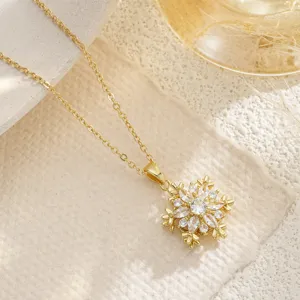 Detailed view of a rotating gold snowflake pendant necklace with sparkling cubic zirconia stones