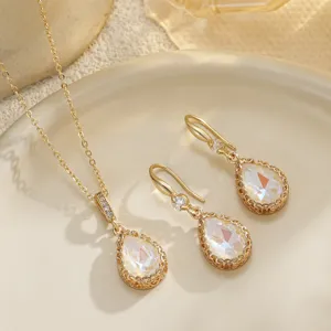 Close-up of teardrop bridal jewelry set featuring iridescent stones and gold filigree.