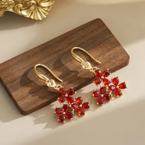 Detail shot of vintage Chinese style red flower crystal drop earrings on wood