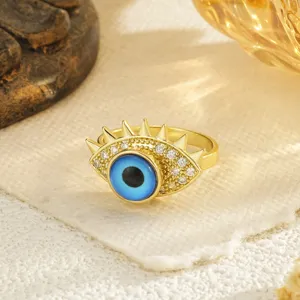 Vista macro de un anillo de ojo turco chapado en oro con piedras azules y circonitas.