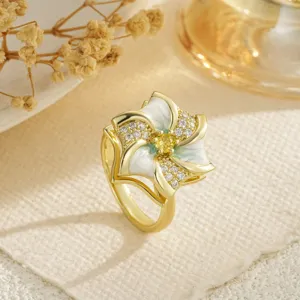 Detail of a rotating flower ring featuring gold plating and sparkling zircon stones