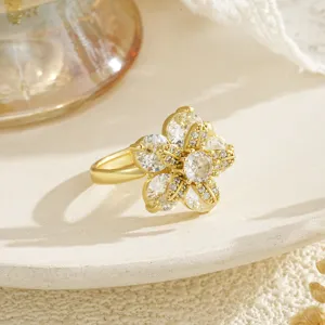 Close-up detail of an elegant gold-plated rotating flower ring with clear crystals