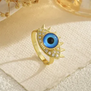 Primer plano de un anillo giratorio de ojo turco dorado con circonitas micropavé