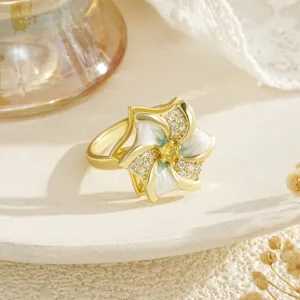 Macro detail of a rotating flower ring with white enamel petals and sparkling zircons