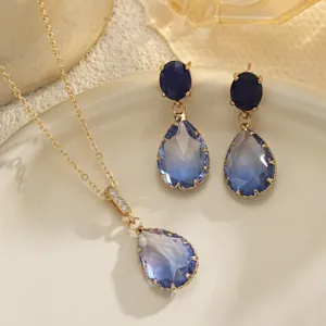 Primer plano de colgante y pendientes de cristal azul en un plato de cerámica