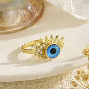 Detalle macro de un anillo giratorio de ojo turco chapado en oro con circonitas brillantes
