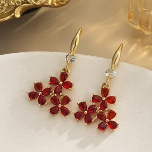 Detailed macro of vintage copper earrings with vibrant red crystal flower petals
