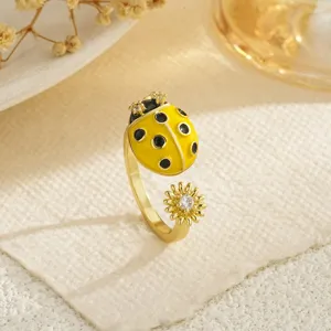 Close-up of golden ladybug and daisy open ring with sparkling zircon detail