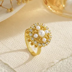 Detailed close-up of a rotating gold flower ring with pearls and crystals