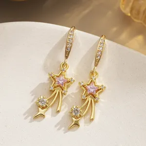 Exquisite detail of gold-plated shooting star drop earrings with sparkling pink zircon stones