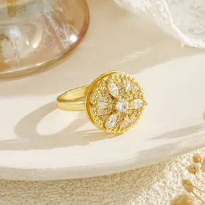 Close-up of gold-plated rotating ring with sparkling floral cubic zirconia design.