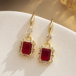 Macro detail of vintage red emerald-cut zircon earrings with a sparkling clear stone halo