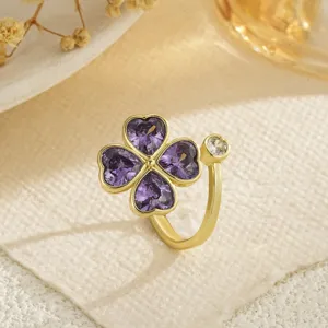 Detailed view of a gold-finished rotatable four-leaf clover ring with purple heart zircons