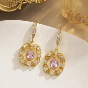 Elegant gold-plated dangle earrings featuring a pink oval zircon and hollow lace design.