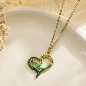 Detail of gold heart pendant necklace with green enamel MOM lettering and rhinestones