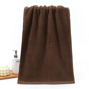 Detailed view of a soft brown pure cotton towel showing its plush looped texture and quality