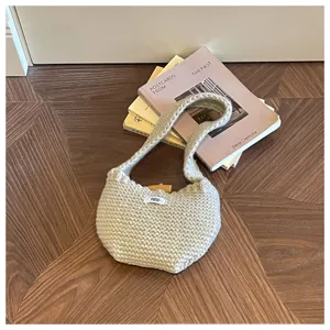 Hand-knitted beige crochet handbag with wooden toggle closure and 'egg.' tag detail.