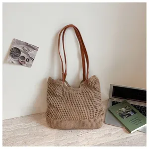 Handmade brown hollow-out woven tote bag with slim shoulder straps for beach vacations