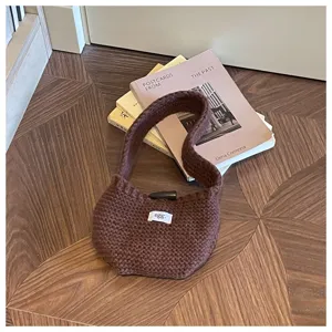 Brown knitted crochet handbag with wood toggle closure and egg label details on books
