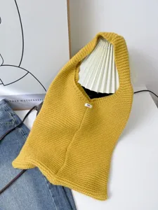 Close-up of a large yellow knitted tote bag with minimalist tag detail for women