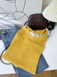 High-angle detail shot of yellow knitted large capacity tote bag with lifestyle props