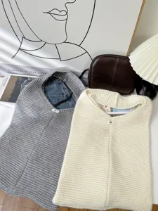 Detailed view of grey and cream oversized knitted tote bags in a lifestyle setting
