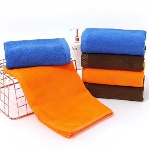 Multi-colored soft absorbent cotton towels stacked and displayed with basket and dispenser.