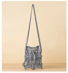 Detailed macro shot of grey pleated knitted crossbody bag with unique wavy texture design.