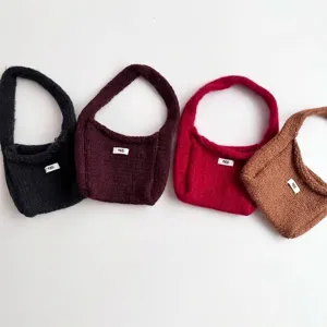 Set of four stylish minimalist knit handbags in black, burgundy, red, and brown colors