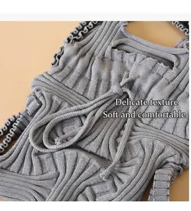 Close-up detail of grey knitted mini crossbody bag showing soft pleated woven texture