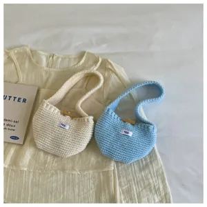 Two stylish mini knitted handbags in cream and light blue colors for earphone storage