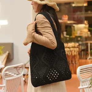 Bolso tote de punto calado negro llevado al hombro en ambiente relajado