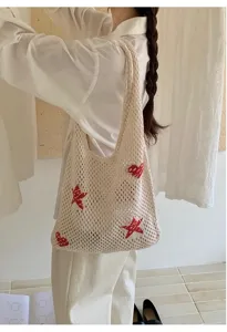 Detailed view of a stylish cream crochet tote bag featuring red heart and star knit patterns