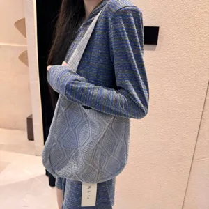 Close-up of a blue cable-knit crossbody bag with a stylish textured pattern